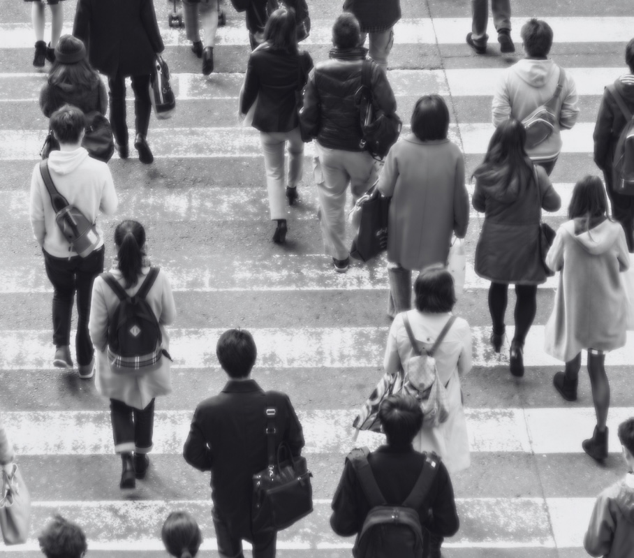 People crossing a busy street describing an active and current society